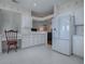 This kitchen shows white cabinets and appliances along with an attached eat-in area and tile flooring at 320 Bentwood Dr, Leesburg, FL 34748