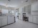 Bright kitchen features white appliances, tile flooring, and a breakfast nook with a table and chairs at 320 Bentwood Dr, Leesburg, FL 34748