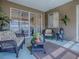 Screened in lanai with wicker seating, glass table, a ceiling fan, and curtains at 320 Bentwood Dr, Leesburg, FL 34748