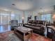 Cozy living room featuring a plush leather sofa, patterned rug, and lots of natural light at 320 Bentwood Dr, Leesburg, FL 34748