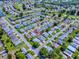 Expansive aerial view of a well-maintained community with lush landscaping, tranquil ponds, and a nearby golf course at 32708 Westwood Loop, Leesburg, FL 34748