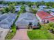 Aerial view of a home with a well-manicured lawn and a brick driveway at 32708 Westwood Loop, Leesburg, FL 34748