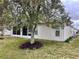 The backyard of this home has an ornamental tree and a screened in lanai at 32708 Westwood Loop, Leesburg, FL 34748