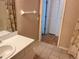 Full bathroom with seashell wallpaper and tan tile flooring at 32708 Westwood Loop, Leesburg, FL 34748