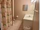 Full bathroom with seashell wallpaper and tan tile flooring at 32708 Westwood Loop, Leesburg, FL 34748