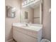 Bathroom featuring a single-sink vanity, a large mirror, and vintage wallpaper at 32708 Westwood Loop, Leesburg, FL 34748