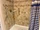 Accessible shower equipped with grab bars, a seat, and tiled walls at 32708 Westwood Loop, Leesburg, FL 34748
