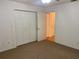 Bedroom with white closets and neutral walls, and hardwood floor view into next room at 32708 Westwood Loop, Leesburg, FL 34748