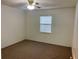 Bedroom with neutral walls, brown carpet, and a bright window at 32708 Westwood Loop, Leesburg, FL 34748