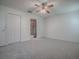 Spacious bedroom featuring neutral carpet, ceiling fan, and access to the en-suite bathroom at 32708 Westwood Loop, Leesburg, FL 34748