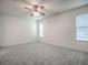This bedroom has neutral walls, carpeted floors, a ceiling fan, and is lit with natural light at 32708 Westwood Loop, Leesburg, FL 34748