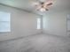 Bright bedroom with neutral walls, carpeted floor, ceiling fan, and light from the window at 32708 Westwood Loop, Leesburg, FL 34748