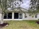 A rear view of this home features an enclosed porch, and partial tree coverage at 32708 Westwood Loop, Leesburg, FL 34748