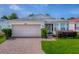 Inviting single-story home with a two-car garage, brick driveway and well-maintained landscaping at 32708 Westwood Loop, Leesburg, FL 34748