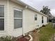 The exterior of this home has simple landscaping and vinyl siding at 32708 Westwood Loop, Leesburg, FL 34748