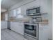Modern kitchen features stainless steel appliances, white cabinetry, and neutral countertops at 32708 Westwood Loop, Leesburg, FL 34748