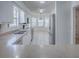 Bright kitchen features white cabinetry, stainless steel appliances, and tiled floors, offering a clean design at 32708 Westwood Loop, Leesburg, FL 34748