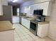 The kitchen features stainless steel appliances, a tile floor, and white cabinets at 32708 Westwood Loop, Leesburg, FL 34748