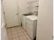 A well-lit laundry room features a washer, dryer, and storage shelving at 32708 Westwood Loop, Leesburg, FL 34748