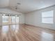 Spacious living room boasts wood floors, sliding glass doors to a screened porch, and bright natural light at 32708 Westwood Loop, Leesburg, FL 34748