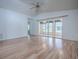 Airy living room features wood flooring, ceiling fan, and sliding glass doors accessing the screened lanai at 32708 Westwood Loop, Leesburg, FL 34748