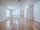 Open-concept living room features wood floors, and a view of the kitchen through a half wall at 32708 Westwood Loop, Leesburg, FL 34748