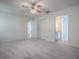 Carpeted main bedroom provides a ceiling fan, neutral walls, and access to the attached bath and walk-in closet at 32708 Westwood Loop, Leesburg, FL 34748