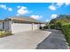 Spacious three-car garage with ample parking and a well-maintained driveway, accented by lush greenery at 39136 Harbor Hills Blvd, Lady Lake, FL 32159