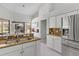 Bright kitchen featuring granite countertops, white cabinetry, and stainless steel refrigerator at 39136 Harbor Hills Blvd, Lady Lake, FL 32159