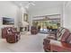 Cozy living room featuring a fireplace, plush leather seating, and access to a screened-in lanai at 39136 Harbor Hills Blvd, Lady Lake, FL 32159