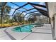 Gorgeous screened-in pool with outdoor grill area and lush landscaping at 39136 Harbor Hills Blvd, Lady Lake, FL 32159