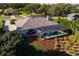 Aerial view showcasing a screened pool with patio, surrounded by lush landscaping, and a well-maintained lawn at 39136 Harbor Hills Blvd, Lady Lake, FL 32159