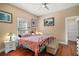 Bedroom featuring a wrought iron bed frame, hardwood floors and an ensuite bathroom at 401 S 6Th St, Leesburg, FL 34748