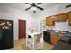 Well-lit kitchen with wood cabinets, black appliances, an island, and an exterior door to the rear yard at 401 S 6Th St, Leesburg, FL 34748