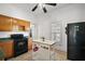 An alternative view of the kitchen with wooden cabinetry and a black refrigerator, plus a mobile kitchen island at 401 S 6Th St, Leesburg, FL 34748