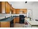 A functional kitchen features wooden cabinetry, a black oven, and a mobile kitchen island at 401 S 6Th St, Leesburg, FL 34748