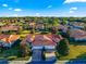 Aerial view features the home's tile roof, attached garage, and lush landscaping at 5049 Harbour Dr # 1, Oxford, FL 34484