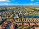 Wide aerial view showcases the home's location, tile roof, landscaping, and community pond at 5049 Harbour Dr # 1, Oxford, FL 34484