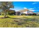 Spacious backyard with green lawn, mature trees, and screened lanai at 5049 Harbour Dr # 1, Oxford, FL 34484