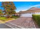 Home featuring a two-car garage, manicured landscaping, and a brick paver driveway at 5049 Harbour Dr # 1, Oxford, FL 34484