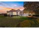 Charming single Gathering home featuring lush landscaping, warm colors, and a red tile roof at sunset at 5049 Harbour Dr # 1, Oxford, FL 34484