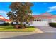 Home featuring a two-car garage, red tile roof, manicured landscaping, and brick paver driveway at 5049 Harbour Dr # 1, Oxford, FL 34484