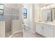 Bathroom with a tiled shower, modern fixtures, white cabinets, and ample lighting, creating a comfortable and functional space at 5413 Sandy Hill Ln, Lady Lake, FL 32159