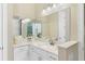 Bathroom with double sinks, white countertops, large mirrors, and modern fixtures, designed for convenience and style at 5413 Sandy Hill Ln, Lady Lake, FL 32159