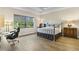 Bedroom featuring wood-look tile, large window, and a comfortable bed, perfect for relaxation and peaceful sleep at 5413 Sandy Hill Ln, Lady Lake, FL 32159