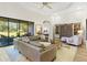 Spacious living room featuring hardwood floors, a ceiling fan, a large window and leather sofa at 5413 Sandy Hill Ln, Lady Lake, FL 32159