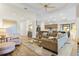 Open-concept living room features a tray ceiling and wood flooring connecting the living area and kitchen at 5413 Sandy Hill Ln, Lady Lake, FL 32159