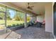 Outdoor screened-in patio featuring brick flooring, a ceiling fan, and outdoor seating at 5413 Sandy Hill Ln, Lady Lake, FL 32159