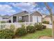 Single-story home featuring a white picket fence, neat landscaping and a gray exterior at 5597 Gracie Ln, The Villages, FL 32163