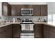 Modern kitchen featuring stainless steel appliances, dark cabinets, and a functional layout, great for cooking at 5597 Gracie Ln, The Villages, FL 32163